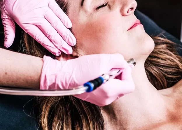 Woman getting microdermabrasion on face